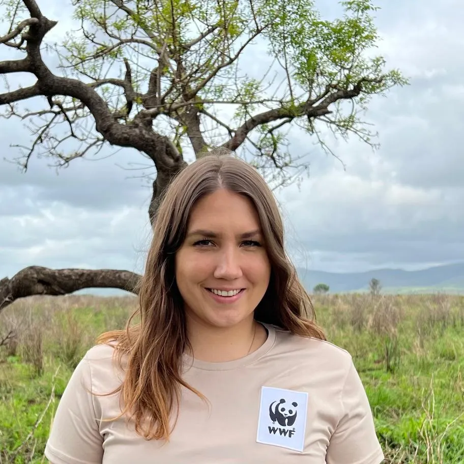 Melina Sowah mit WWF-Shirt vor einem Baum